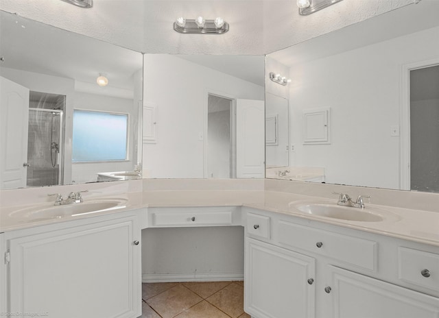 full bathroom with tile patterned flooring, a sink, double vanity, and a shower stall