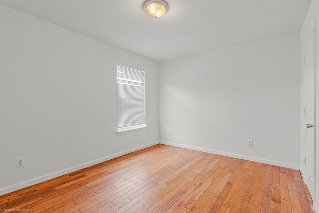 empty room featuring light wood-style floors and baseboards
