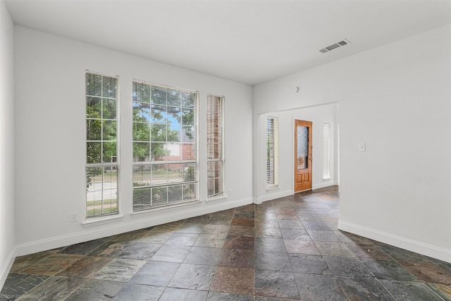 spare room with baseboards, visible vents, and stone tile floors