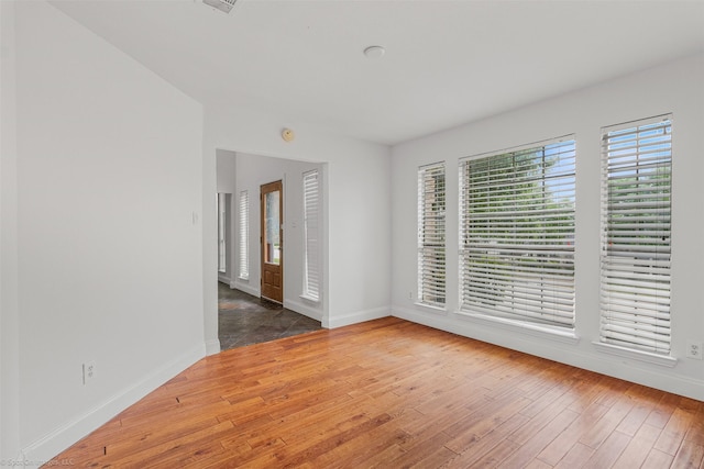 empty room with baseboards and wood-type flooring