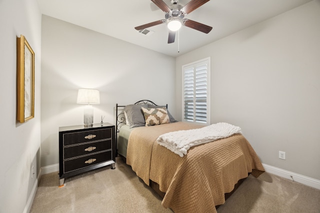 bedroom featuring baseboards, visible vents, a ceiling fan, and light colored carpet