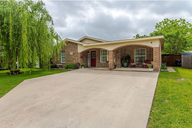 obstructed view of property featuring brick siding and a front lawn