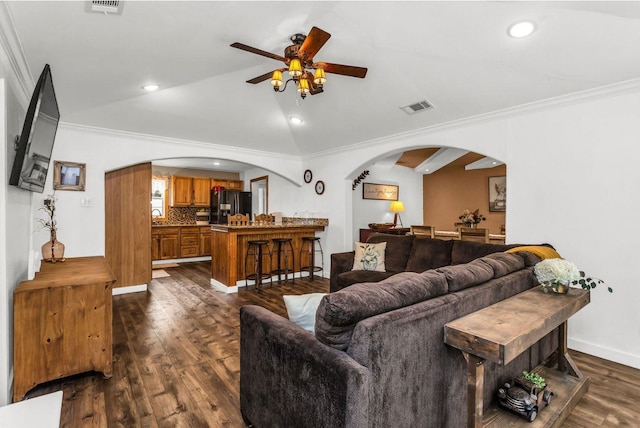 living area with visible vents, arched walkways, ceiling fan, and crown molding