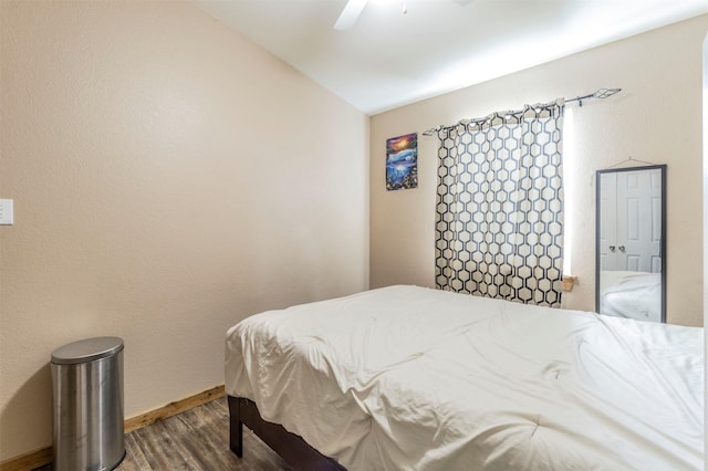 bedroom with baseboards, a ceiling fan, lofted ceiling, and wood finished floors
