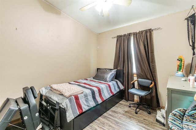 bedroom featuring a ceiling fan, vaulted ceiling, and wood finished floors