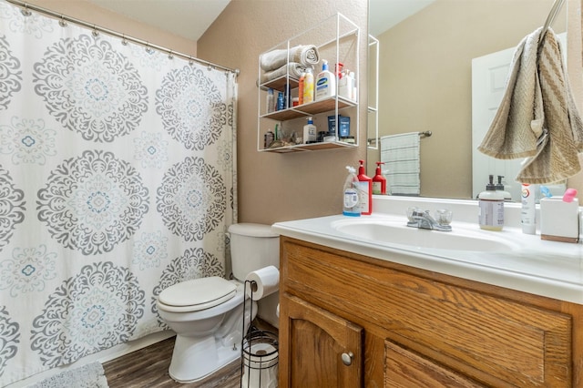 bathroom with vanity, wood finished floors, toilet, and a shower with curtain