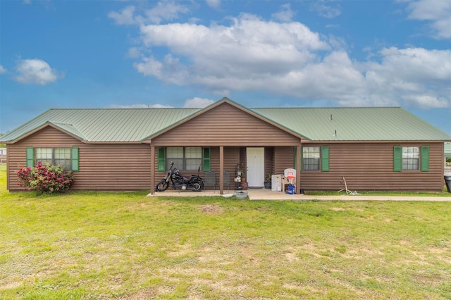 back of house with a yard, log veneer siding, metal roof, and a patio area
