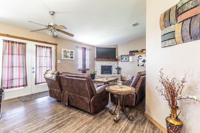 living room with ceiling fan, a fireplace, french doors, wood finished floors, and visible vents