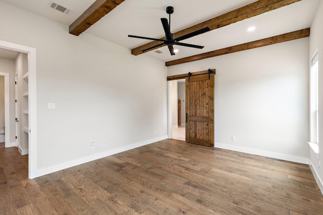 8408 Fullerton Dr, Cleburne, TX 76033 - empty room featuring ceiling fan, visible vents, wood finished floors, a barn door, and beamed ceiling