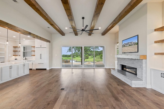 8408 Fullerton Dr, Cleburne, TX 76033 - unfurnished living room featuring beamed ceiling, a ceiling fan, dark wood-style floors, and a brick fireplace