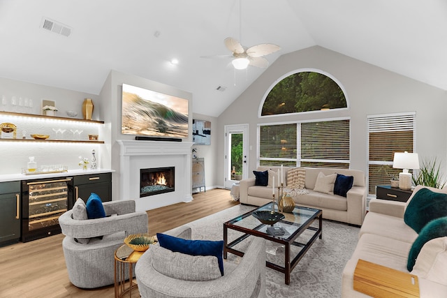 5604 Turtle Way, Mckinney, TX 75072 - living room with wine cooler, bar, ceiling fan, light wood-style flooring, and high vaulted ceiling