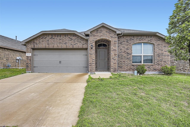 view of front of house featuring an attached garage, concrete driveway, a front lawn, and brick siding