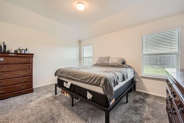 bedroom with baseboards and dark carpet