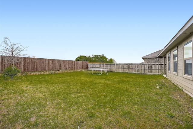 view of yard featuring a fenced backyard and a trampoline