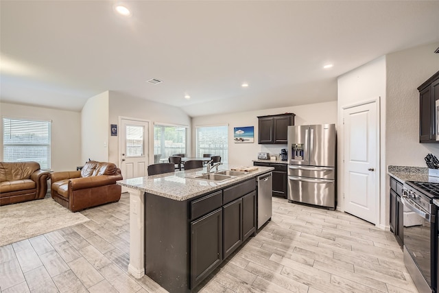 kitchen with visible vents, light wood-type flooring, a sink, open floor plan, and stainless steel appliances