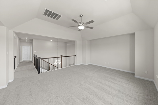 carpeted empty room featuring vaulted ceiling, baseboards, a ceiling fan, and visible vents
