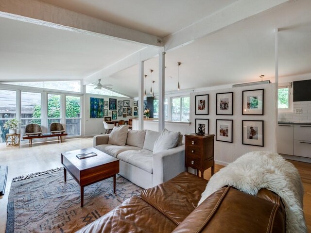 living room with ceiling fan, vaulted ceiling with beams, and wood finished floors