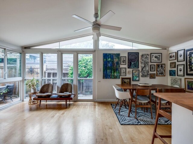 dining room featuring ceiling fan, vaulted ceiling, hardwood / wood-style floors, and a wealth of natural light