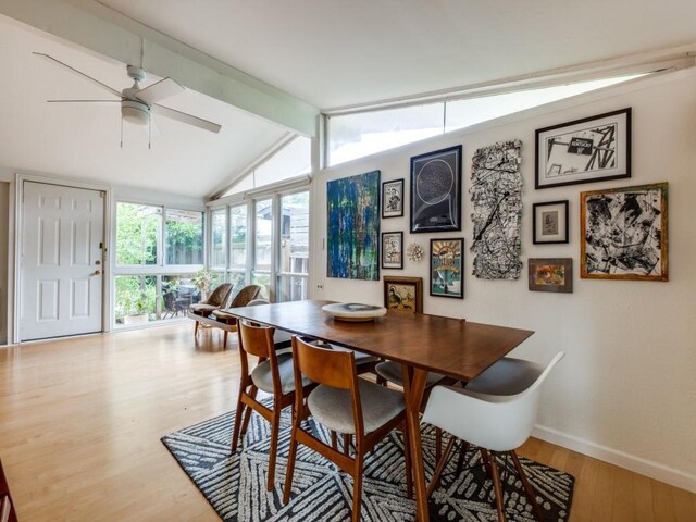 dining area featuring a ceiling fan, baseboards, lofted ceiling with beams, and wood finished floors