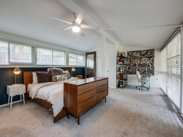carpeted bedroom with a ceiling fan, vaulted ceiling, and multiple windows