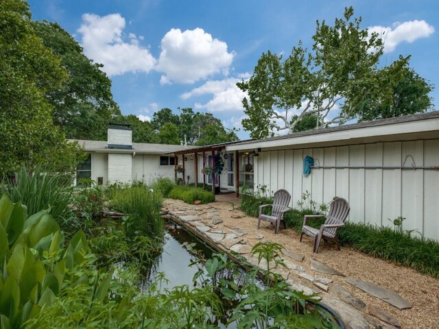 back of property featuring board and batten siding and a chimney
