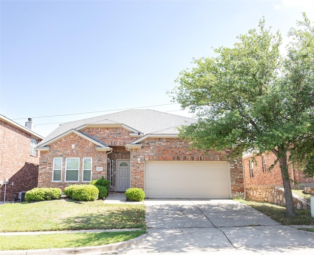 view of front facade featuring roof with shingles, a front lawn, brick siding, a garage, and driveway