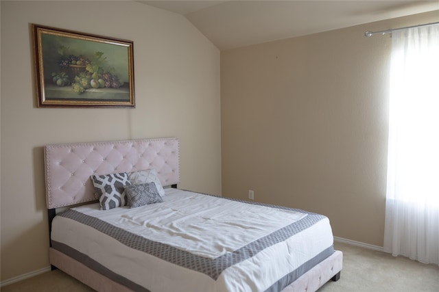 carpeted bedroom featuring baseboards and vaulted ceiling