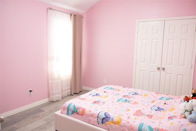 bedroom featuring baseboards, a closet, and light wood-style flooring