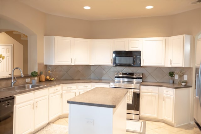 kitchen featuring a kitchen island, arched walkways, a sink, light tile patterned floors, and black appliances