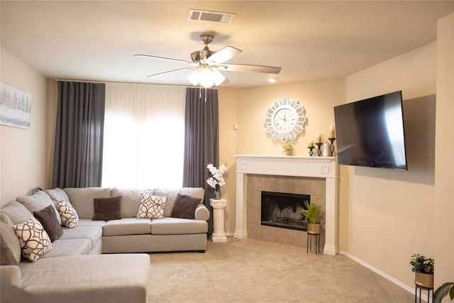 living area featuring carpet floors, ceiling fan, a tile fireplace, and visible vents