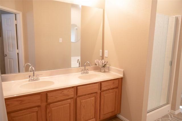 bathroom with double vanity, a sink, and a stall shower