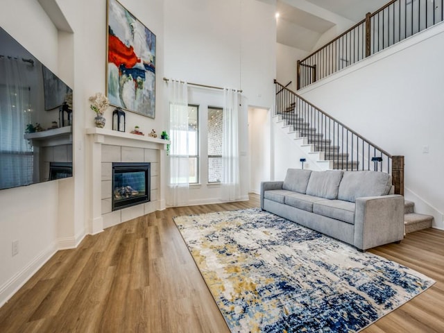 2513 Silver Leaf Dr, Northlake, TX 76226 - living area featuring a fireplace, wood finished floors, stairway, baseboards, and a high ceiling