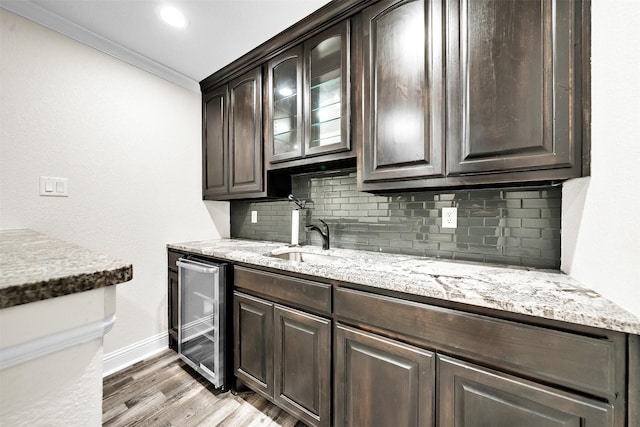 7839 Blanchard Way, Fort Worth, TX 76126 - kitchen with dark brown cabinets, beverage cooler, baseboards, light wood-type flooring, and backsplash