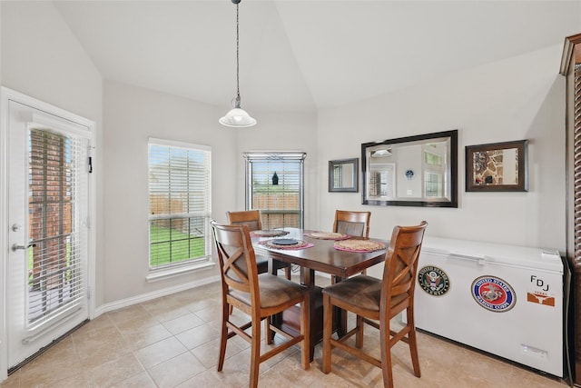 dining room featuring light tile patterned floors and lofted ceiling