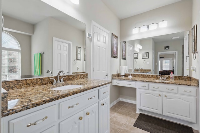 full bathroom with vanity, tile patterned floors, baseboards, and ensuite bath