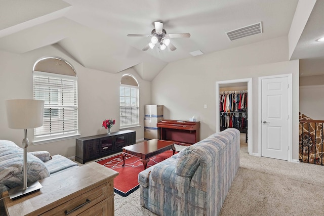 living area with visible vents, ceiling fan, lofted ceiling, and light carpet
