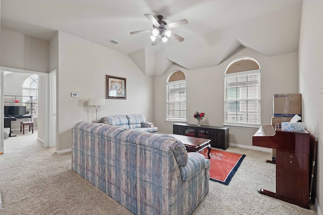 carpeted living area featuring a ceiling fan, baseboards, visible vents, and vaulted ceiling