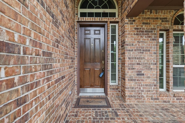 entrance to property featuring brick siding