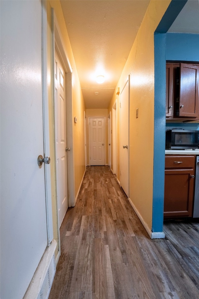 hall featuring baseboards and dark wood-style floors