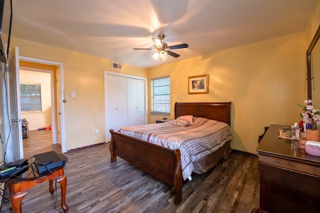 bedroom featuring ceiling fan, baseboards, visible vents, dark wood-style floors, and a closet