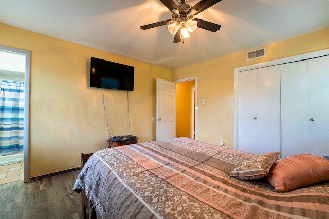 bedroom with ceiling fan, baseboards, wood finished floors, visible vents, and a closet