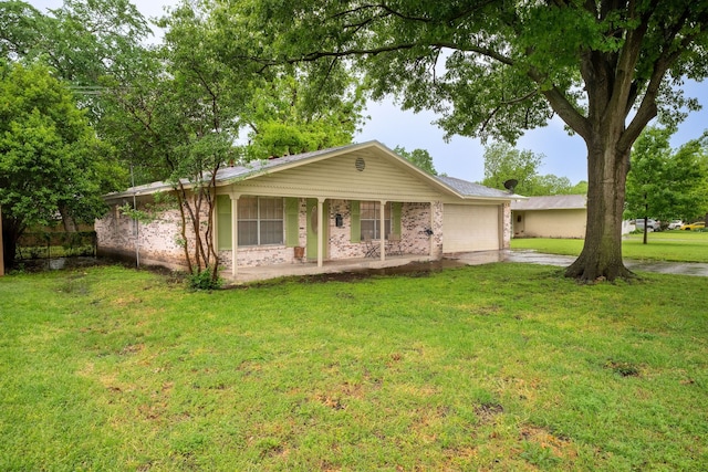 single story home featuring a porch, driveway, a front yard, brick siding, and an attached garage