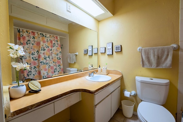 bathroom with toilet, tile patterned floors, curtained shower, and vanity