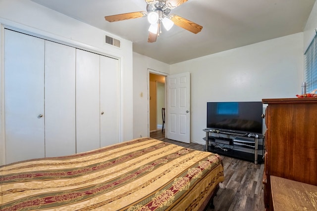 bedroom featuring visible vents, a ceiling fan, dark wood-type flooring, and a closet