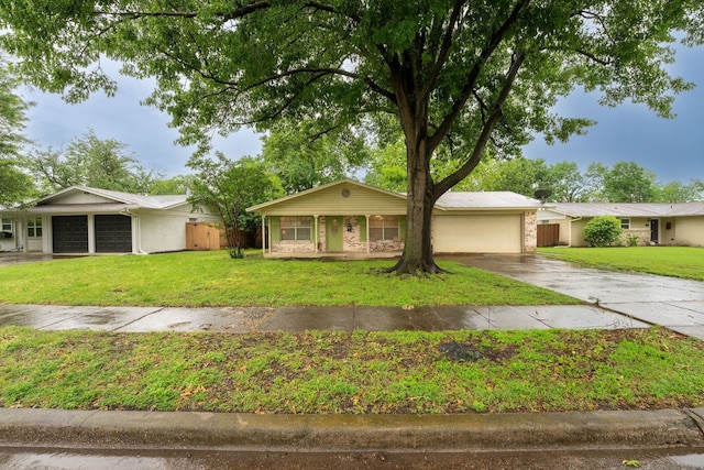 ranch-style house with an attached garage, fence, driveway, and a front yard