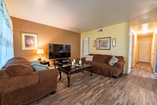 living room featuring visible vents and wood finished floors