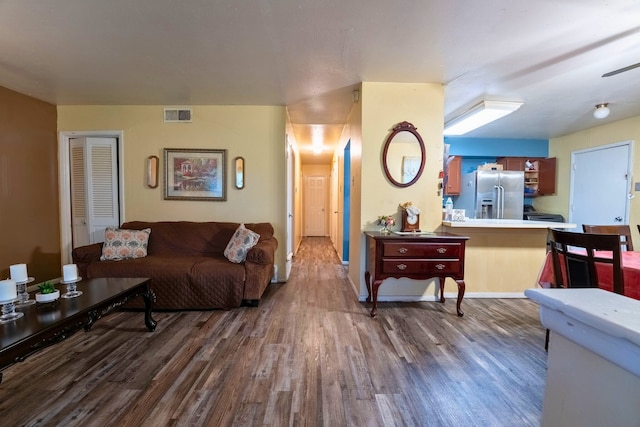 living area with visible vents and wood finished floors