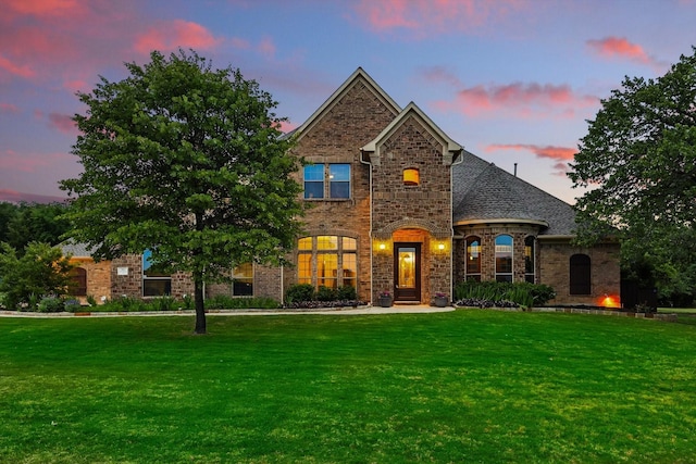 view of front of house with brick siding and a front lawn