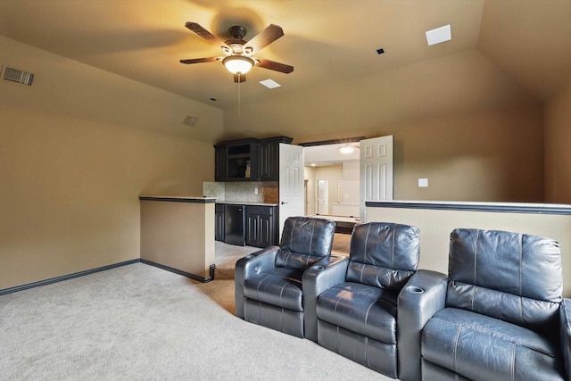 home theater room featuring light carpet, a ceiling fan, baseboards, vaulted ceiling, and visible vents