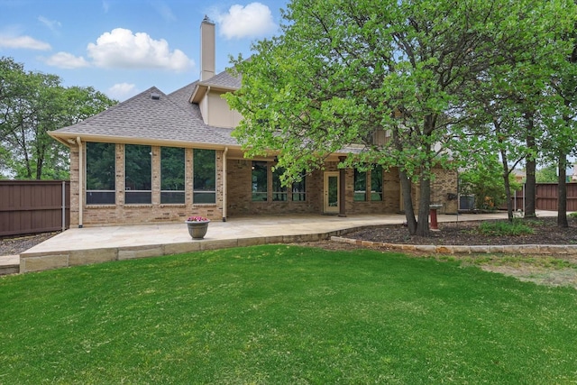 back of house with fence, a patio, a yard, and roof with shingles